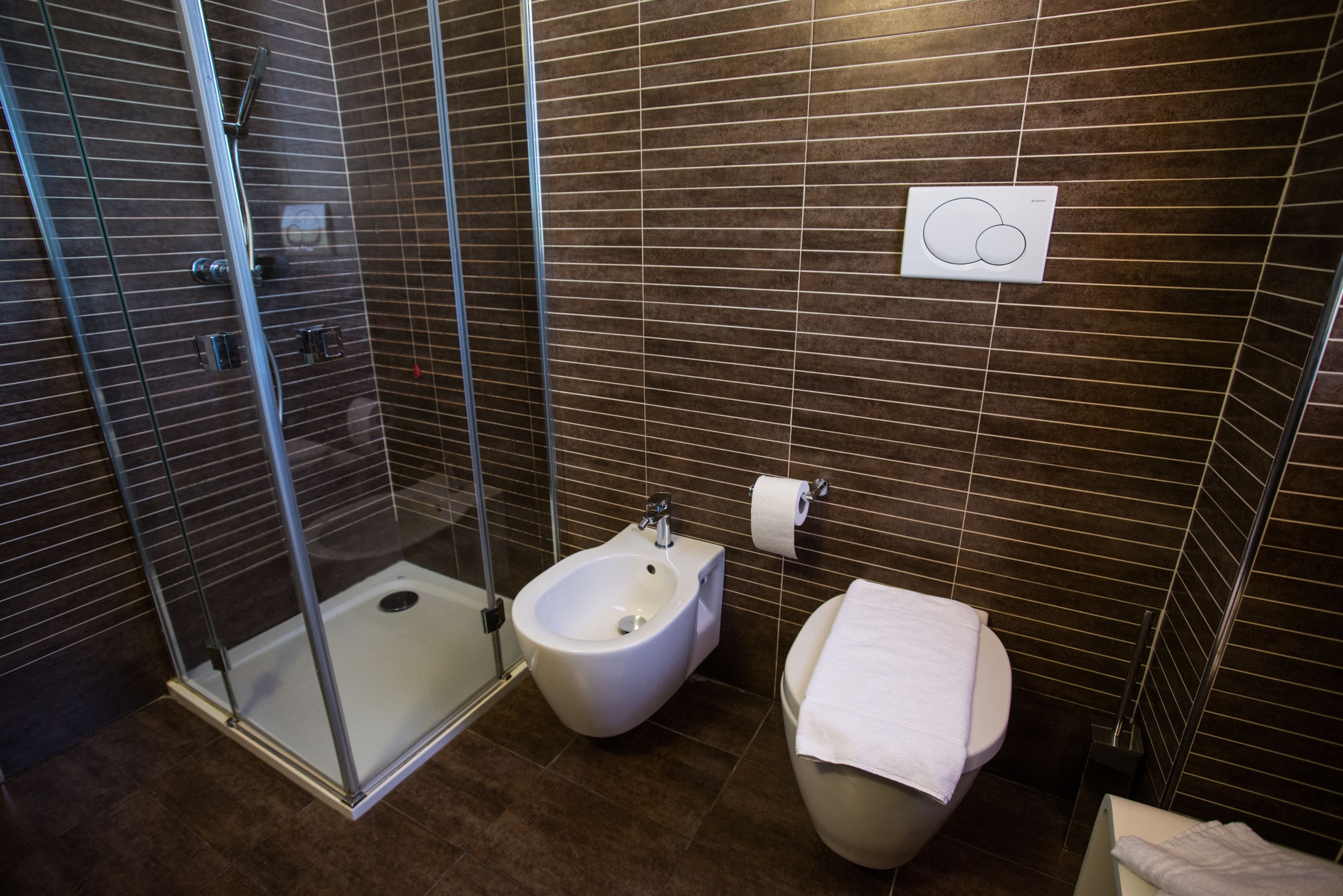 Ein modernes Badezimmer mit einer Duschkabine, einem Bidet und einer Toilette.