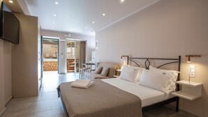 Une chambre d’hôtel moderne dotée d’un grand lit, de tables de chevet, d’un téléviseur à écran plat et offrant une vue sur l’espace extérieur.