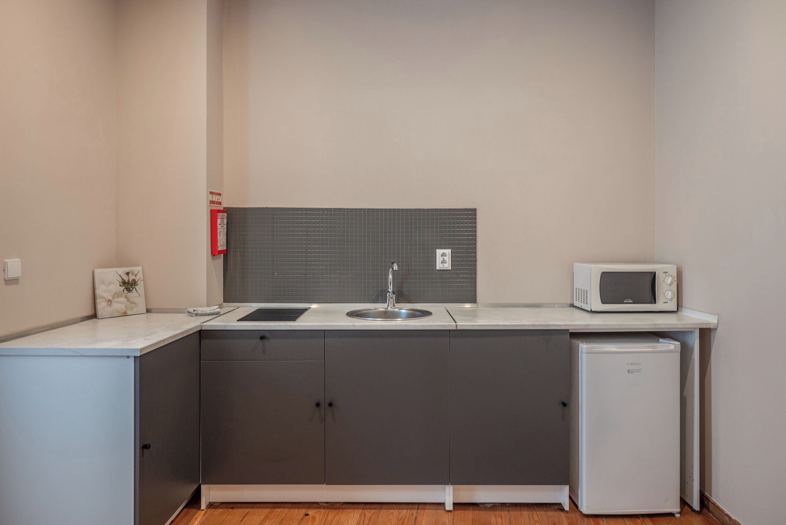 A compact kitchen with a sink, microwave, and refrigerator.