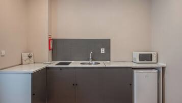 A compact kitchen with a sink, microwave, and refrigerator.