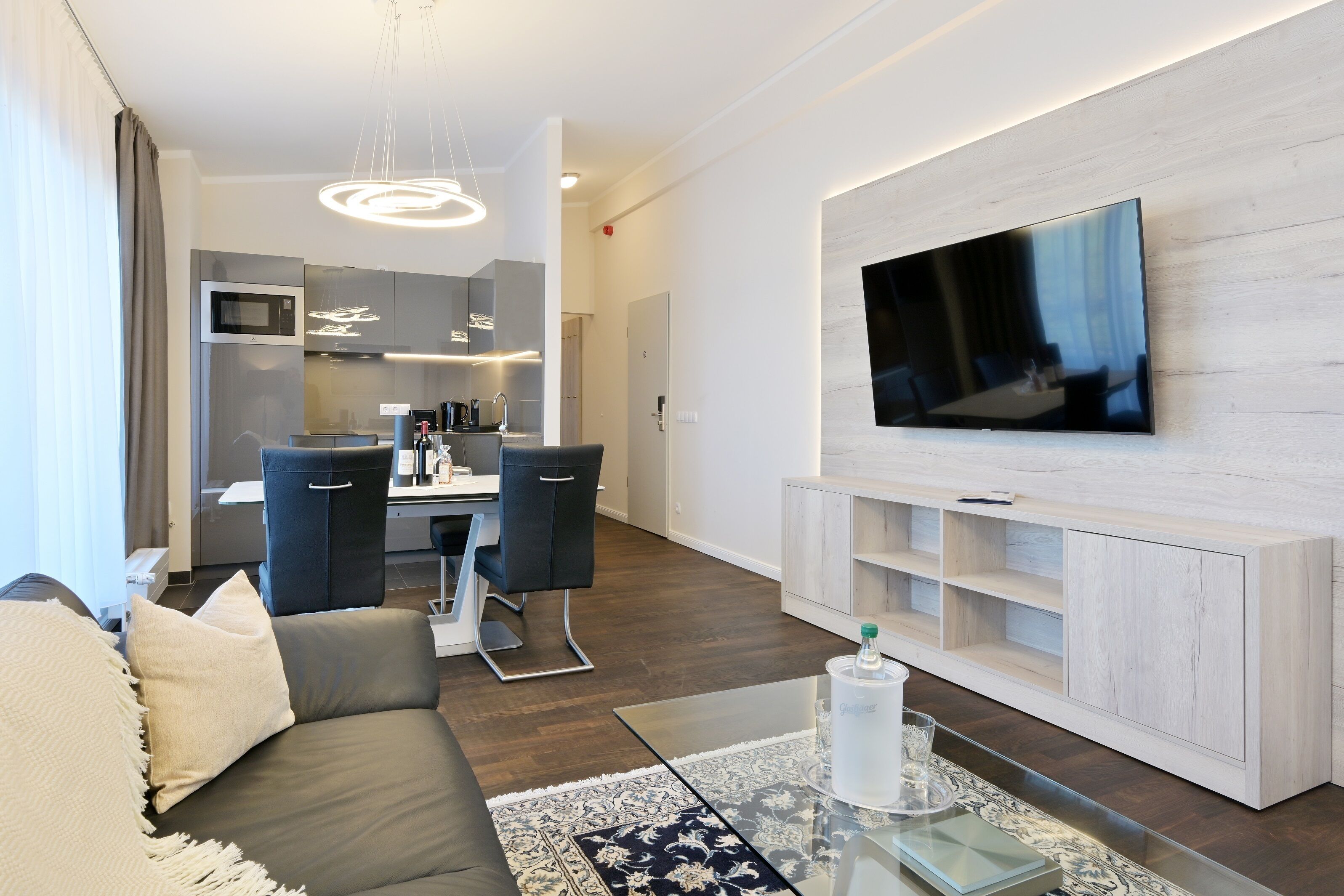 Una sala de estar moderna con un sofá, una mesa de centro y un televisor de pantalla plana montado en la pared.