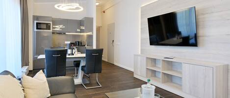 Una sala de estar moderna con un sofá, una mesa de centro y un televisor de pantalla plana montado en la pared.