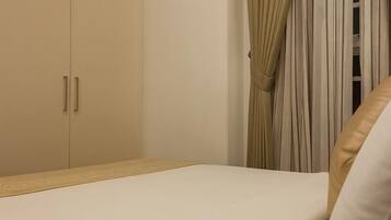 A bedroom with a bed, a wardrobe, and curtains.