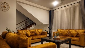 Un salon moderne avec deux canapés, une table basse et un escalier.