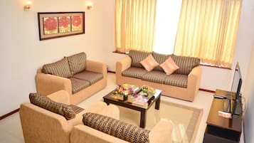 A living room with two sofas, a coffee table, and a TV stand.