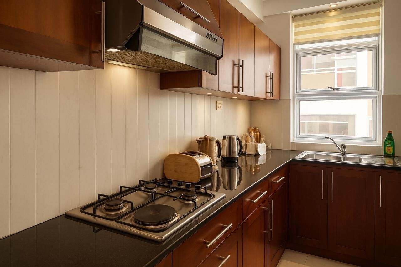 A modern kitchen with wooden cabinets, a stainless steel stove, and a window with blinds.