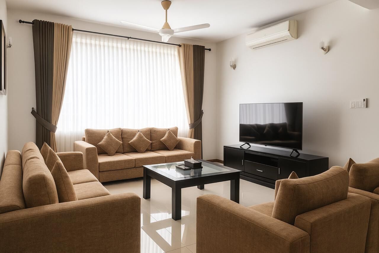 A living room with a sofa set, a coffee table, a TV, and a ceiling fan.