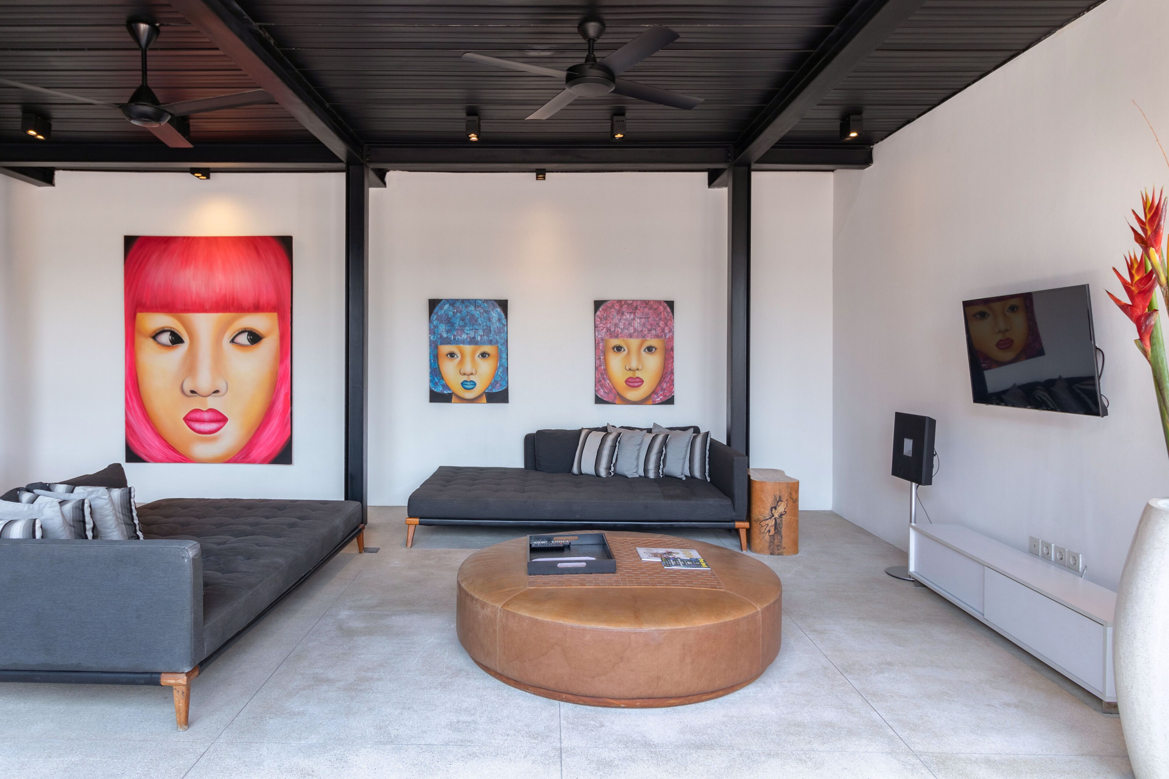 A modern living room with a sofa, a coffee table, and artwork on the walls.