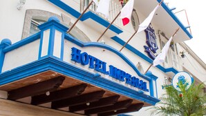 Hotellin sisäänkäynti, jossa on kyltti, jossa lukee ”HOTEL IMPERIAL”, ja useita lippuja.