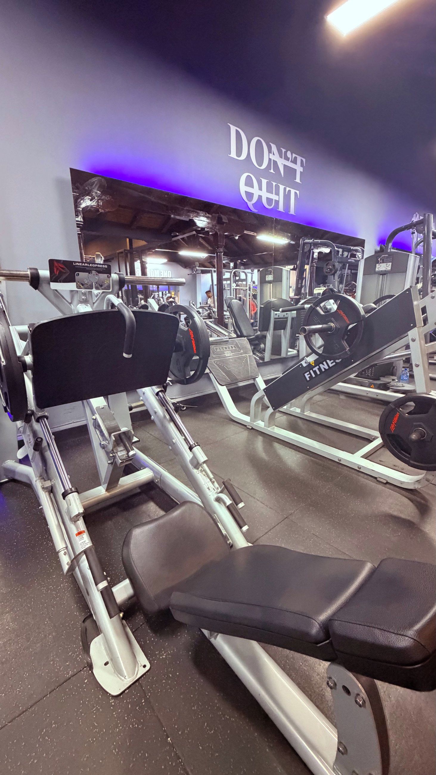 A gym with various exercise equipment, including a bench and weight machines.