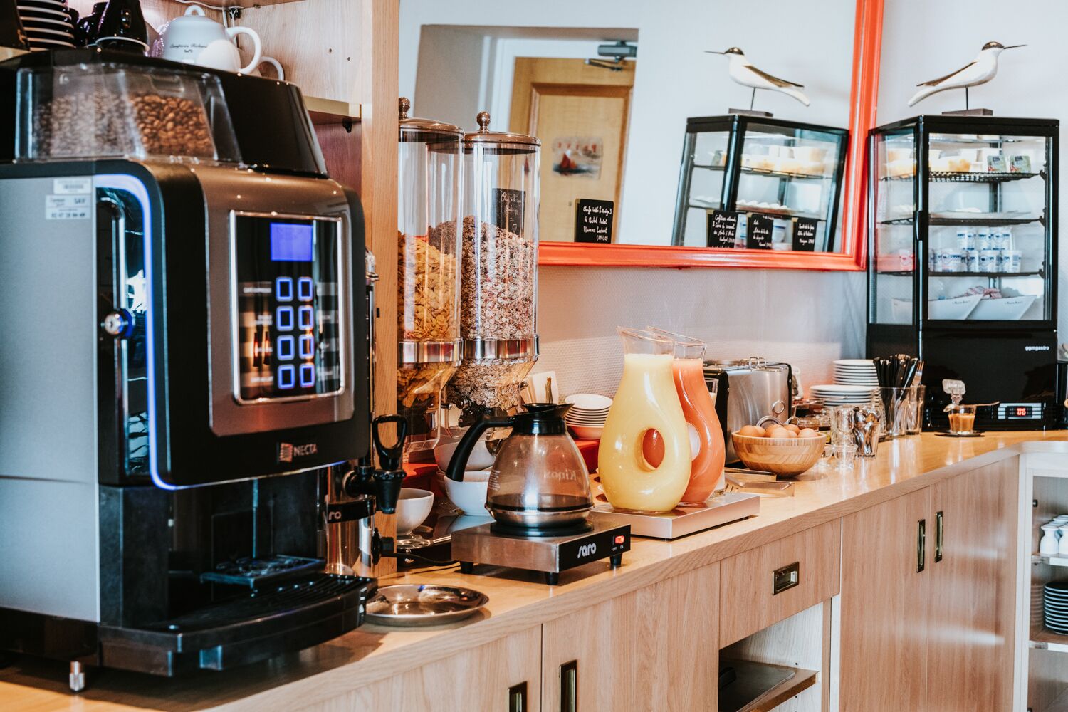 A coffee station with a coffee machine, a kettle, and various coffee containers.