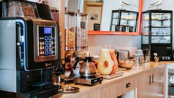 A coffee station with a coffee machine, a kettle, and various coffee containers.