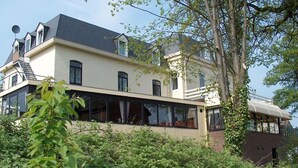 A two-story house with a balcony, large windows, and a satellite dish. - Hotel Restaurant Vijlerhof (Vijlen)