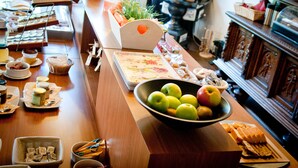 A buffet setup with various food items and a bowl of fruit. - Hotel Restaurant Vijlerhof (Vijlen)