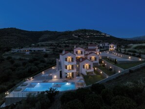 A modern villa with a swimming pool, multiple balconies, and a landscaped garden. - Anassia Villas (Nafplio)