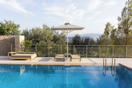 Una piscina al aire libre de temporada, sombrillas