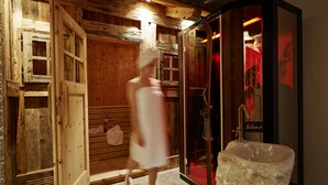 Et træinteriør med sauna, glasdør og vask.