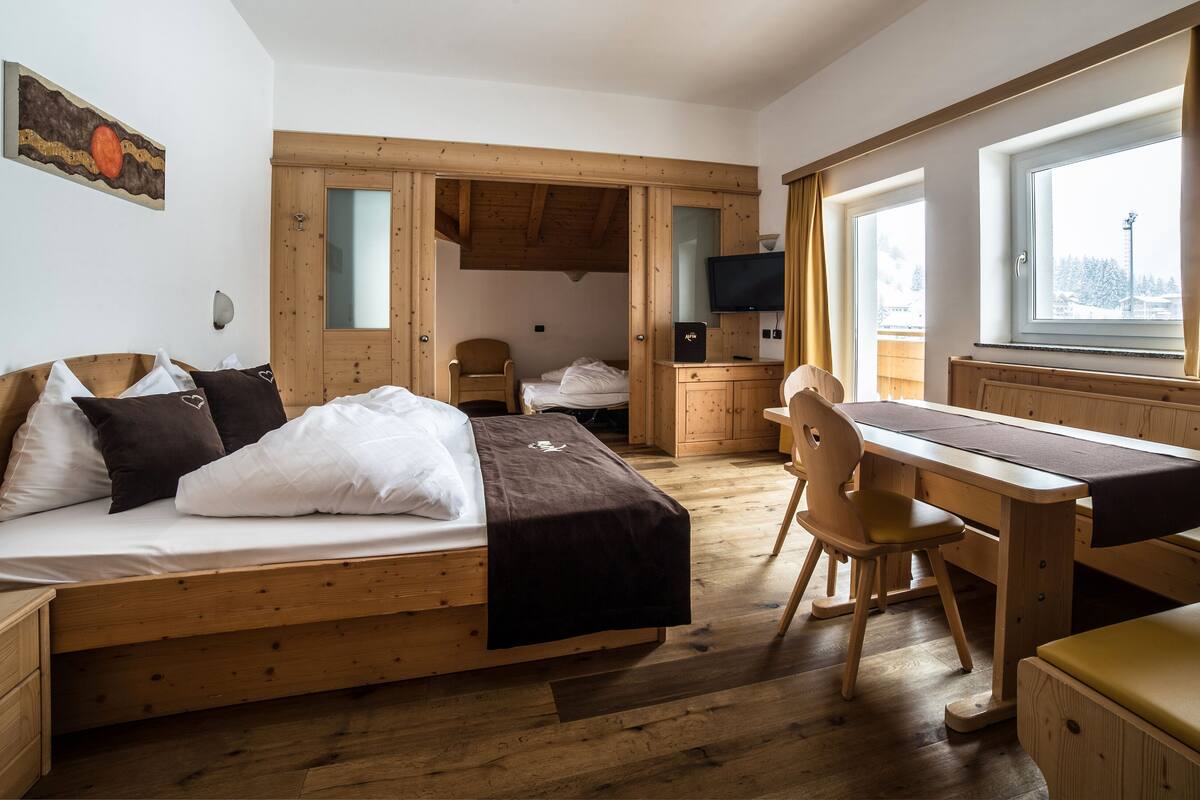 Une pièce confortable avec un lit, un bureau, une chaise et un téléviseur.