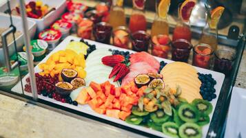 A fruit platter with various sliced fruits and a selection of beverages.