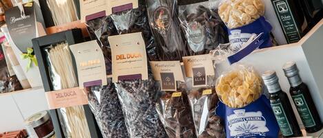 A display of various food products including pasta, chocolates, and olive oil.