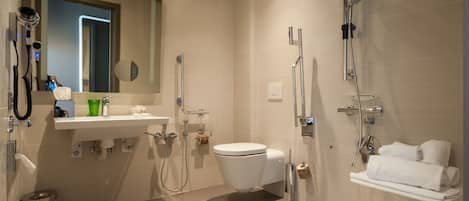 Un baño moderno con inodoro, lavamanos y zona de ducha.