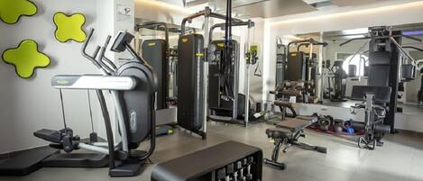 A modern gym with various exercise equipment, including a treadmill, weight machines, and free weights.