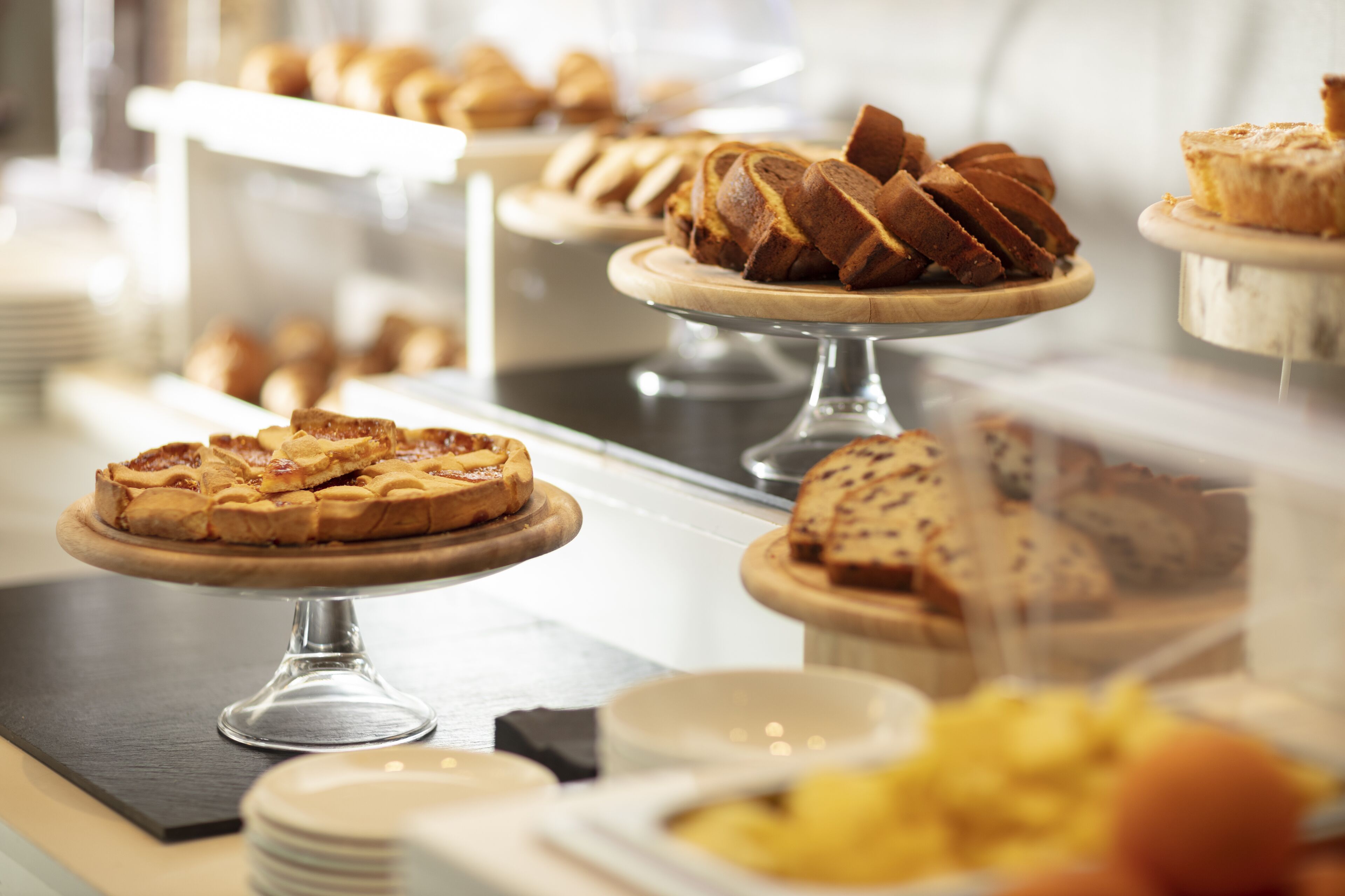 A bakery display with various baked goods on wooden stands.
