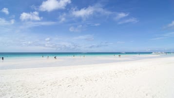 Di pantai, pasir putih, antar-jemput ke pantai, dan handuk pantai