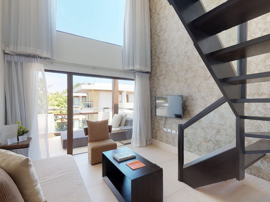 Una sala de estar moderna con un sofá, una mesa de centro y un televisor montado en la pared.