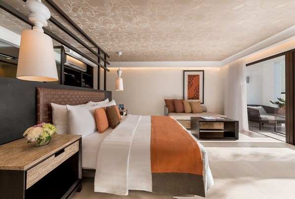 A modern hotel room with a large bed, a sofa, a small table, and a nightstand. - The District Boracay (Boracay Island)