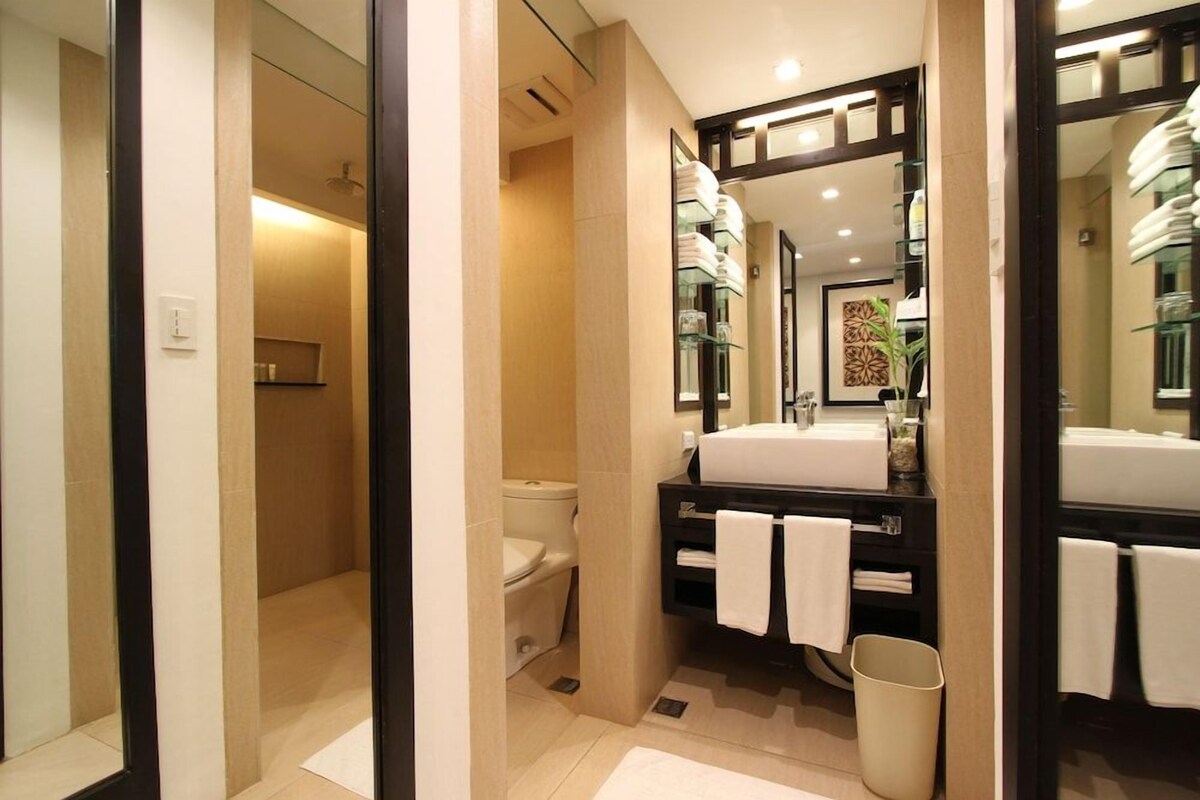 Un baño moderno con inodoro, lavabo y espejo.