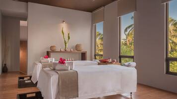 Relax in comfort with two plush beds and a serene view of palm trees.