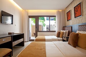Een hotelkamer met een groot bed, een bureau, een televisie en uitzicht op de omgeving.
