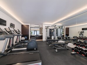 A modern gym with cardio equipment, weight machines, and dumbbells. - The District Boracay (Boracay Island)