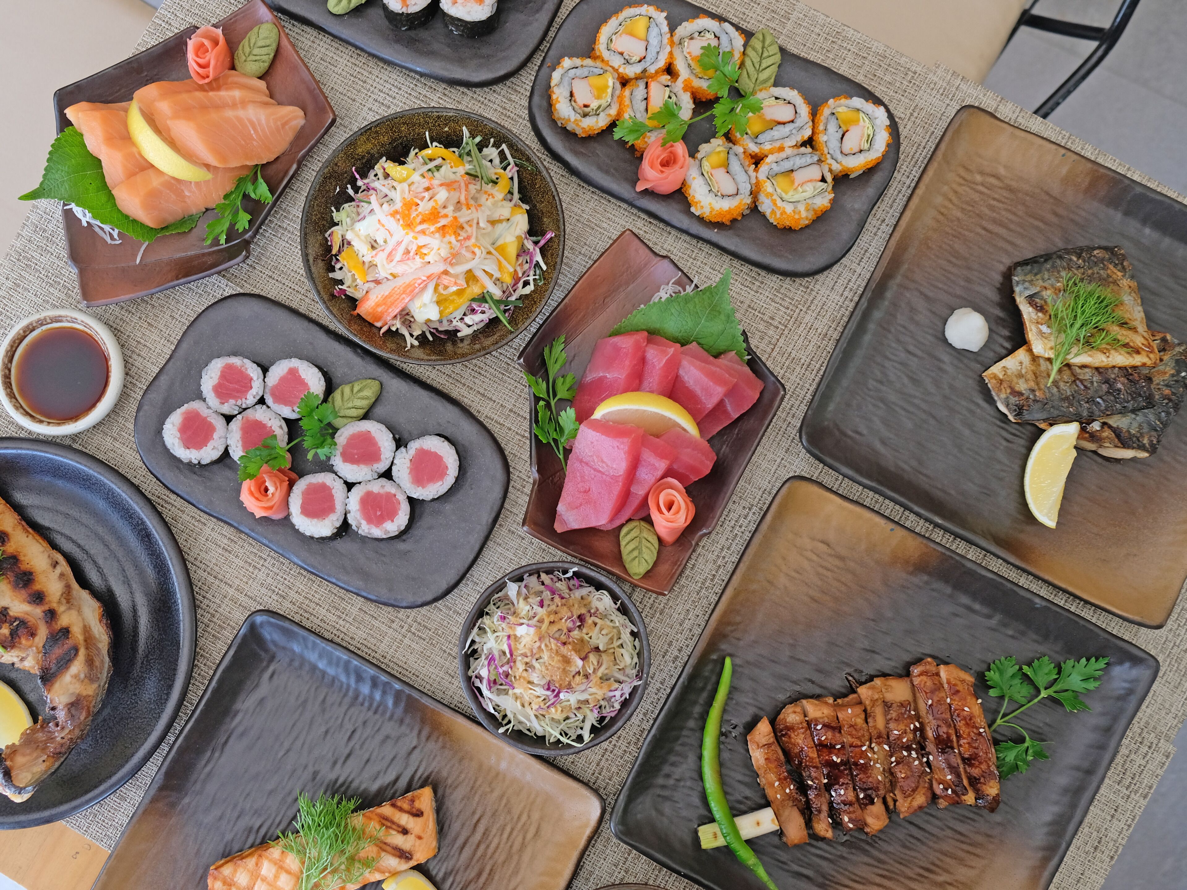 Variedad de sushi y sashimi dispuesto en varios platos.