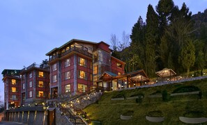A multi-story hotel with a traditional architectural style, featuring balconies and large windows. - Golden Tulip Srinagar (Srinagar)