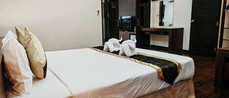 A hotel room with a bed, a desk, and a mirror.