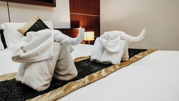 A hotel room with a bed, a lamp, and a wooden headboard.