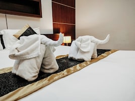 A hotel room with a bed, a lamp, and a wooden headboard.