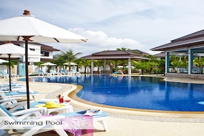 Een buitenzwembad, ligstoelen bij het zwembad