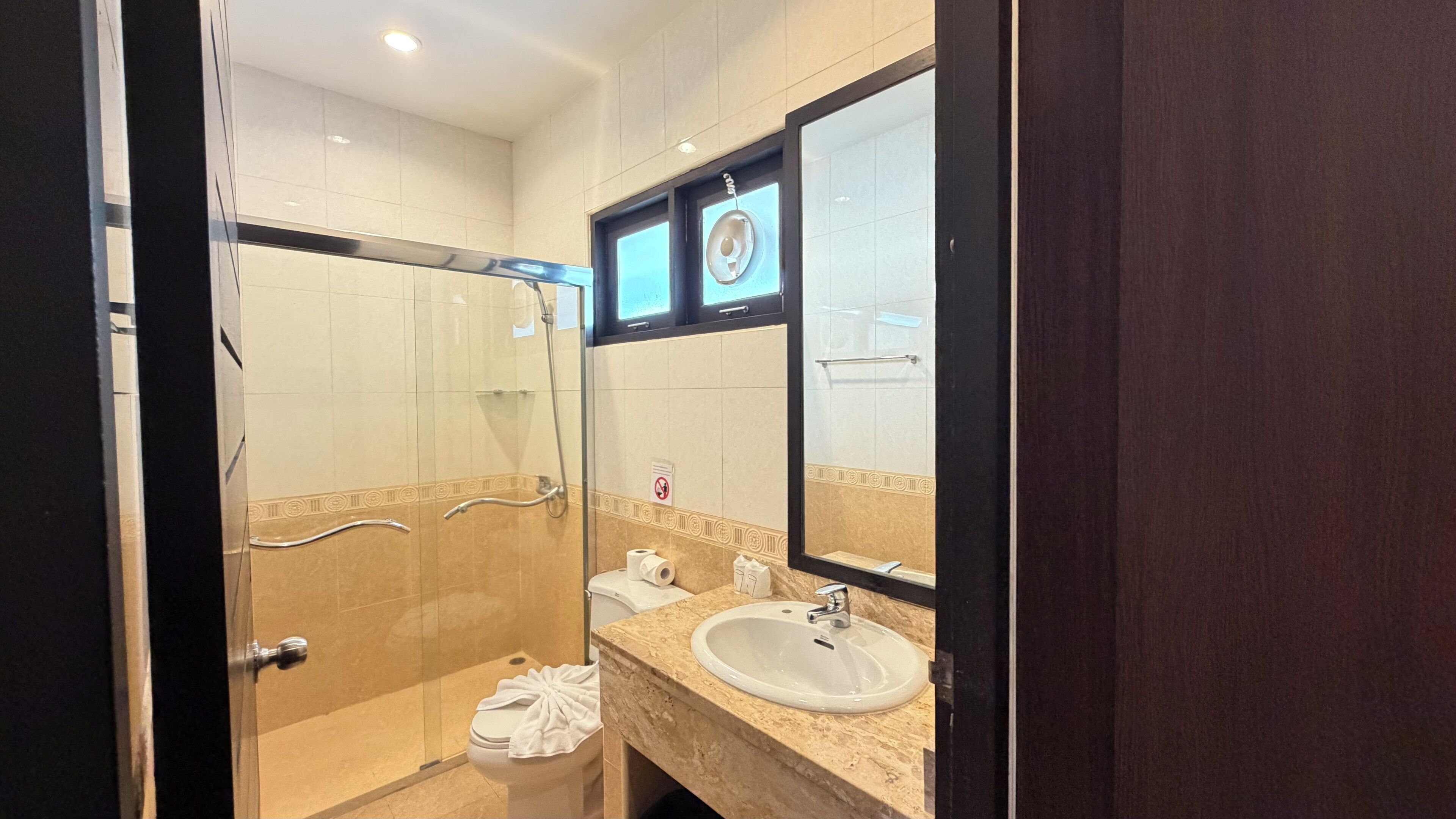 Une salle de bain moderne avec une douche à parois de verre, un lavabo et un grand miroir.