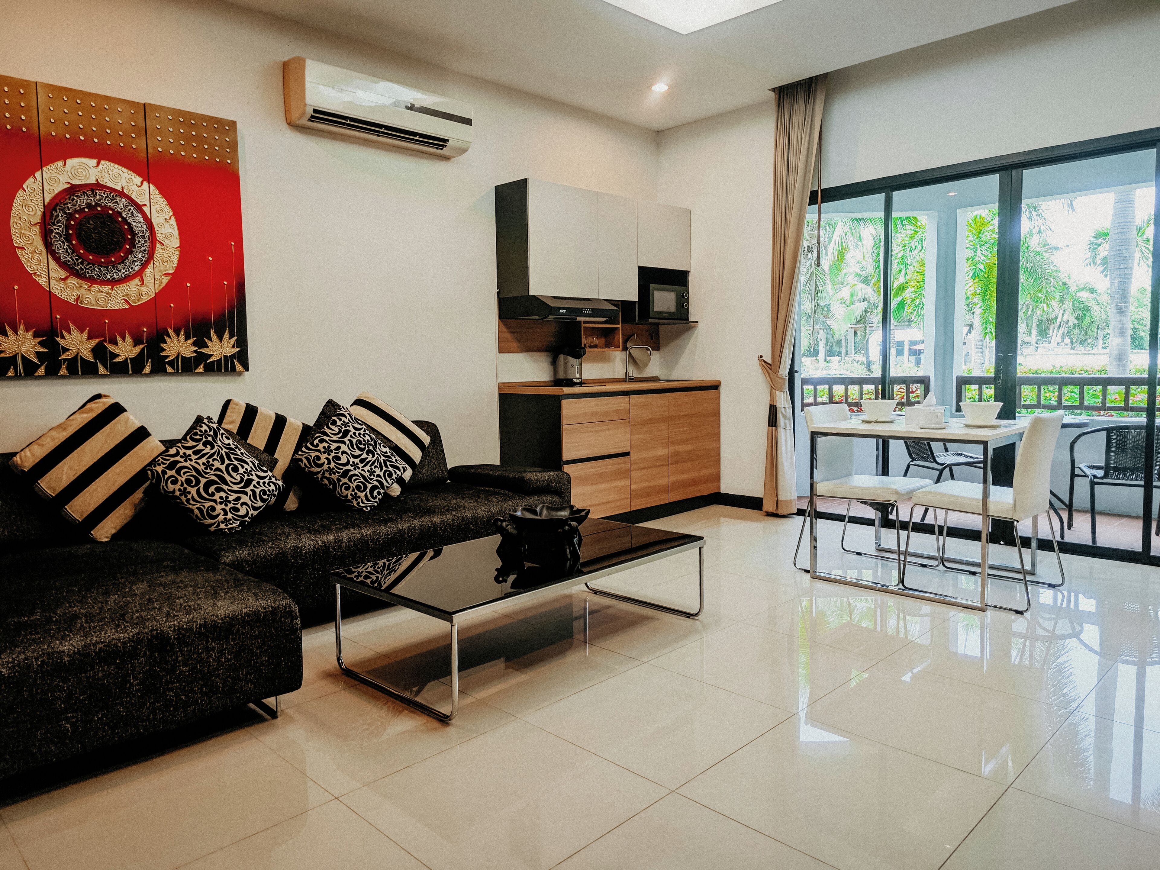 Una sala de estar moderna con un sofá, una mesa de centro y un comedor con una mesa y sillas.