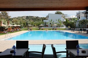 Una piscina al aire libre, sombrillas, tumbonas