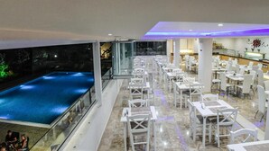 A rooftop dining area with a pool and outdoor seating. - Vallian Village (Rhodes)