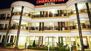 Un hotel de varios pisos con un llamativo letrero que dice 'Charleston Hotel'.