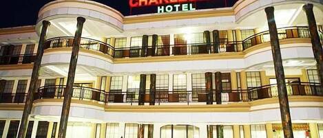 Un hotel de varios pisos con un llamativo letrero que dice 'Charleston Hotel'.