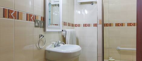 A bathroom with a sink, mirror, towel rack, and a shower area.