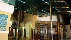 Un interior espacioso con una escalera central, varias zonas de estar y un techo alto con paneles de vidrio.
