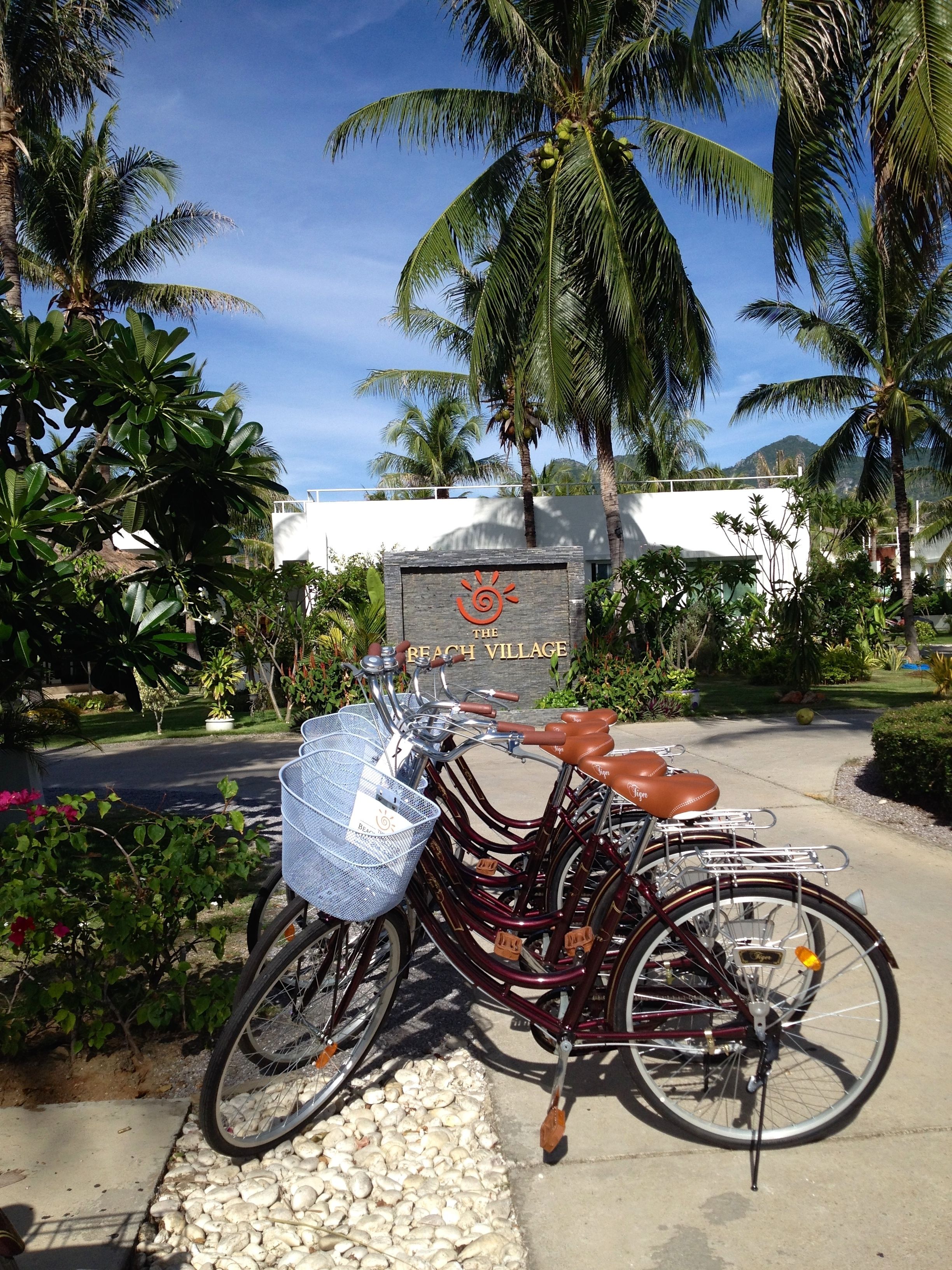 Una bicicleta estacionada frente a un letrero que dice "The Beach Village".