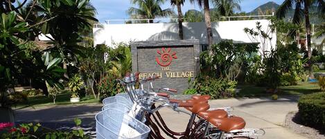 Una bicicleta estacionada frente a un letrero que dice "The Beach Village".
